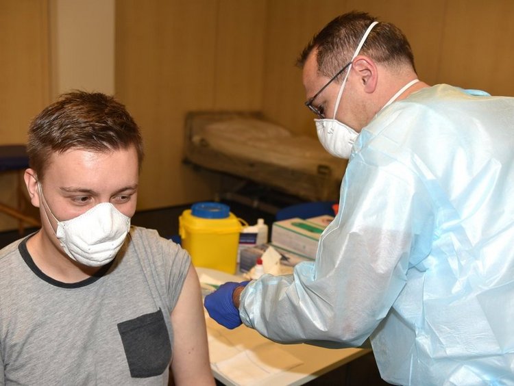 Zwei Männer mit FFP2 Masken in Impf-Situation