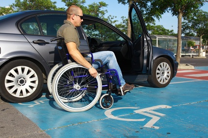 Mann in einem Rollstuhl auf einem Behindertenparkplatz